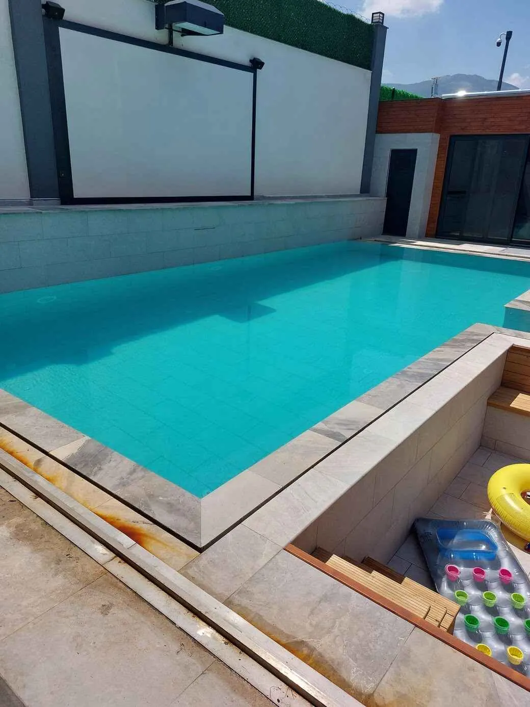  Mavi gökyüzü ve berrak suyuyla baş başa bir yüzme havuzu.